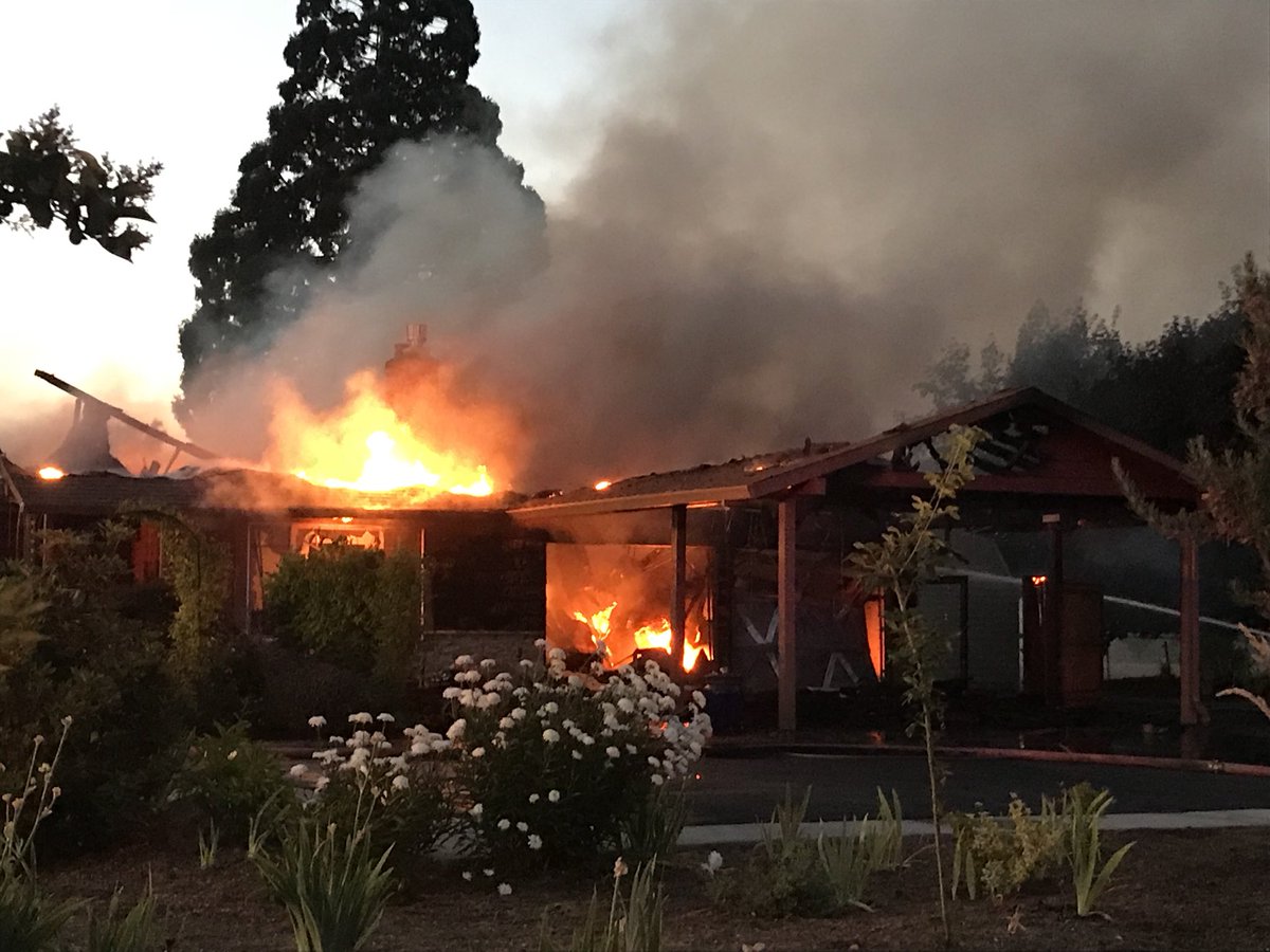 House fire in Hillsboro. Flames still raging from roof. Water and wind challenges for firefighters - no hydrants in area