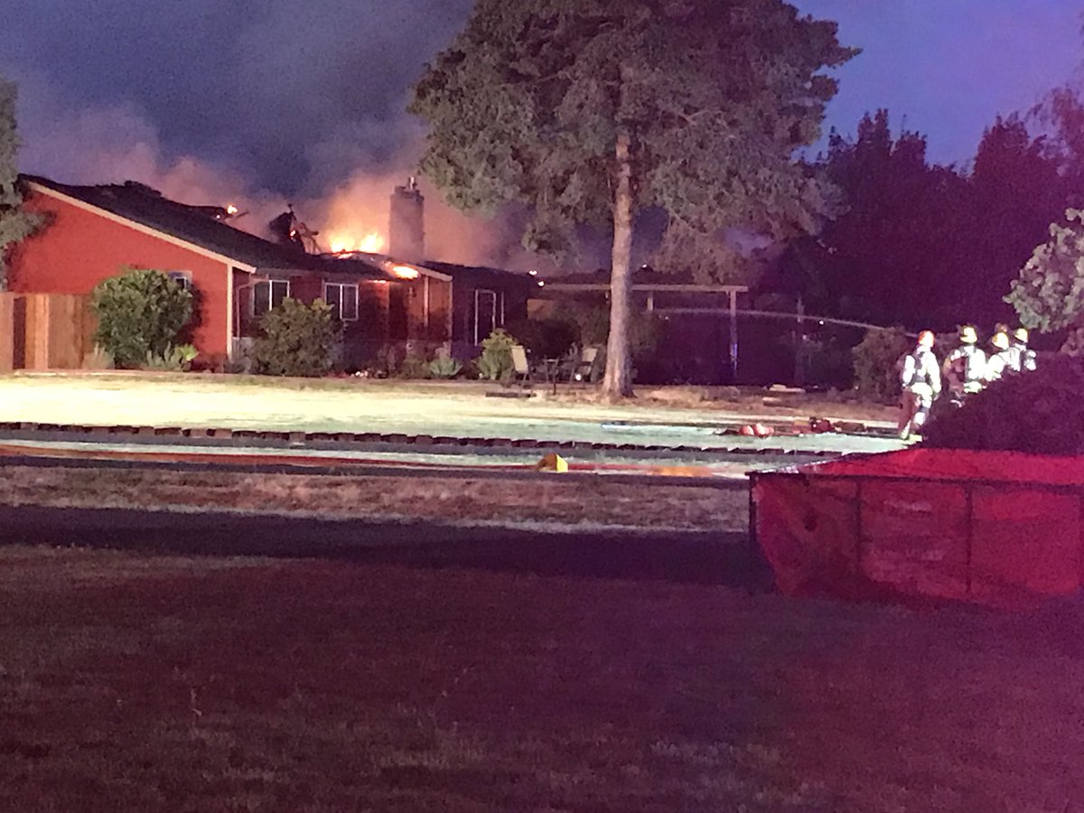 House fire in Hillsboro. Flames still raging from roof. Water and wind challenges for firefighters - no hydrants in area